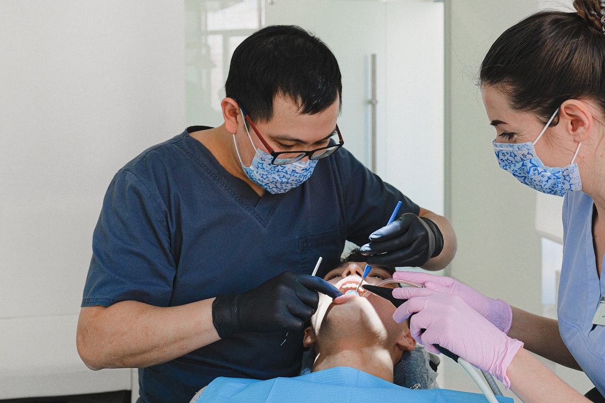 Patient with dentist and dental assistant