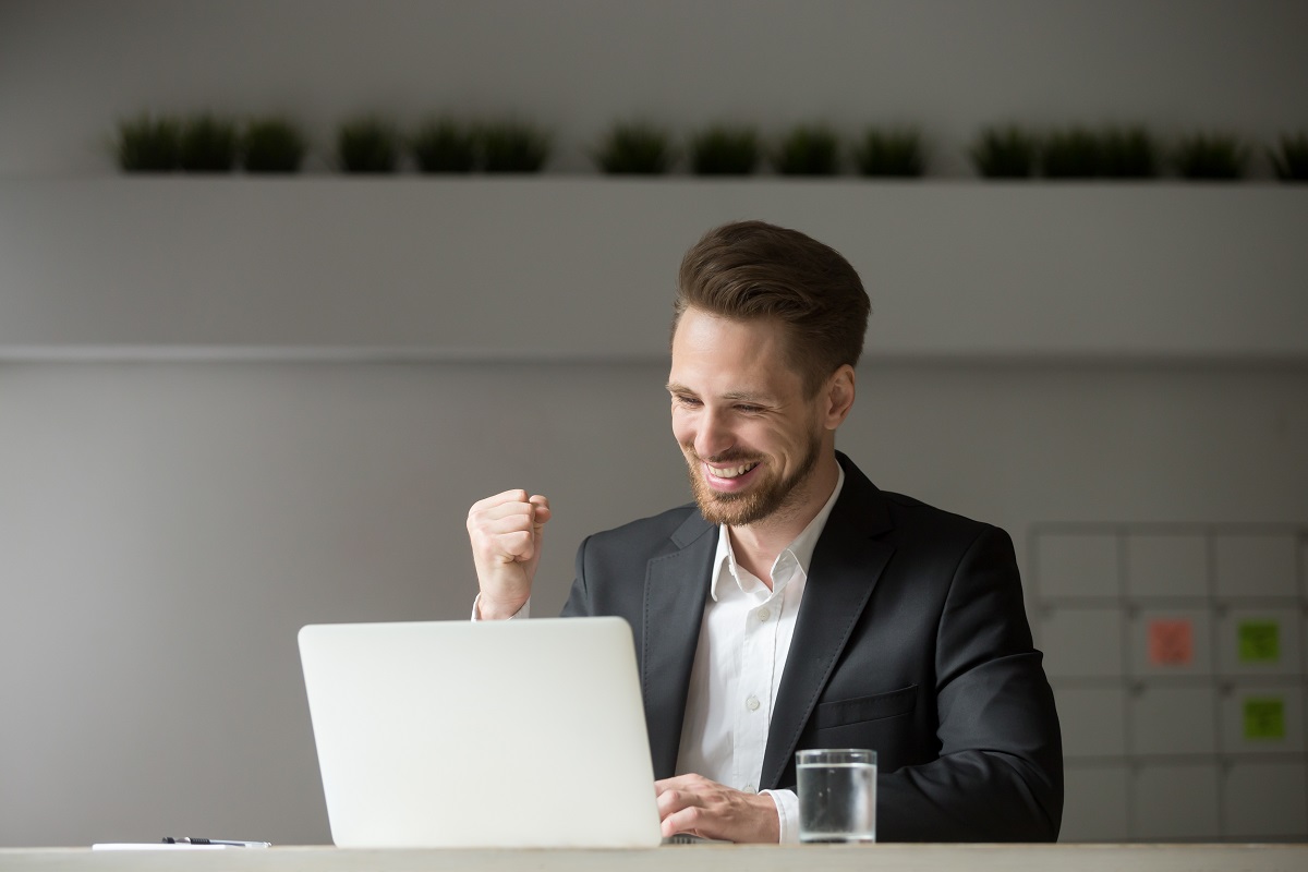 man wearing business attire infront of computer