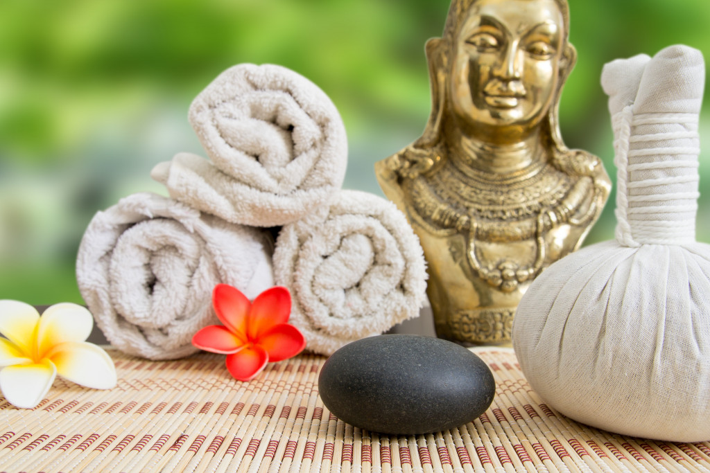 Towels, flowers, and a rock in a wellness center.