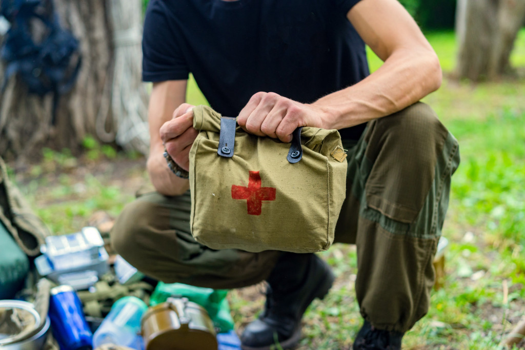 On the ground, a guy with his first-aid kit and other travel items.