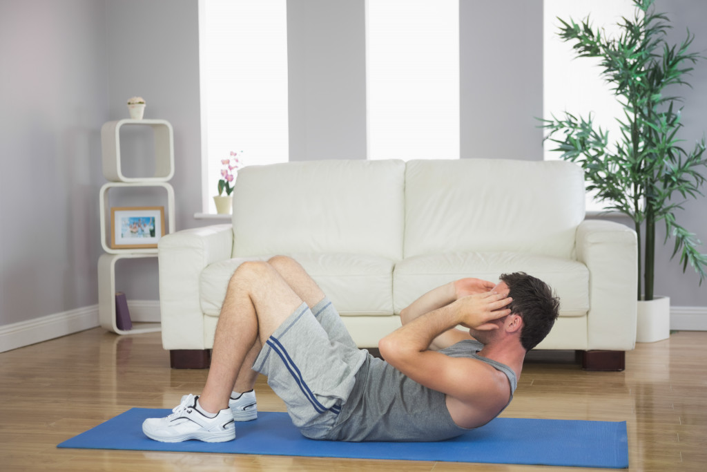 Young man performing crunches at home.