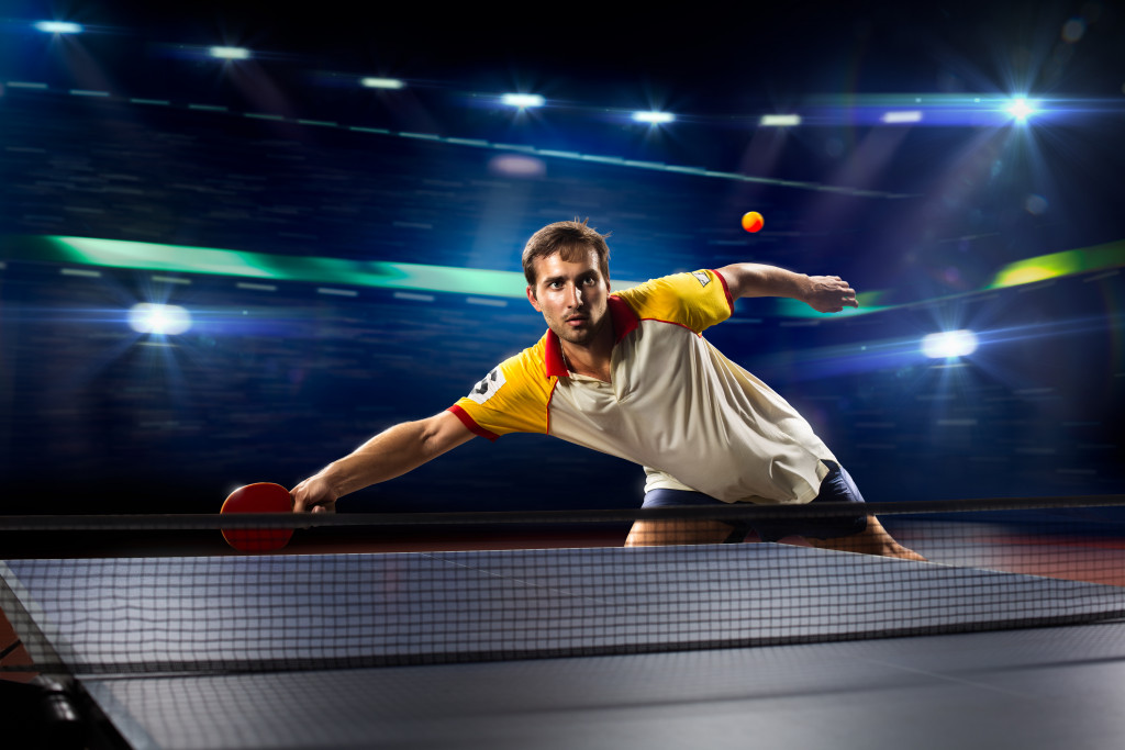 A table tennis player about to hit the ball during a tournament