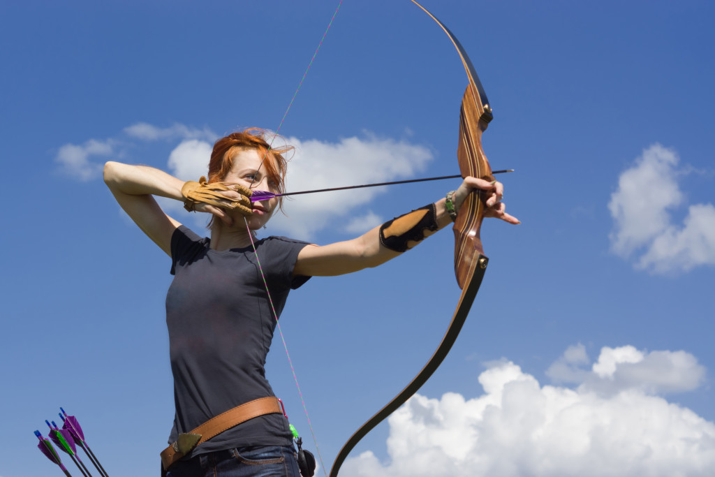 woman serious while holding bow for archery