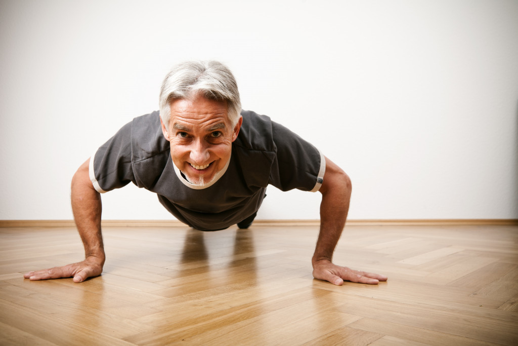 An older man doing pushups on the floor