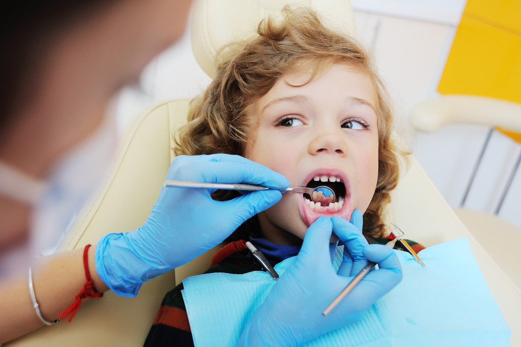 young boy being checked by a dentist