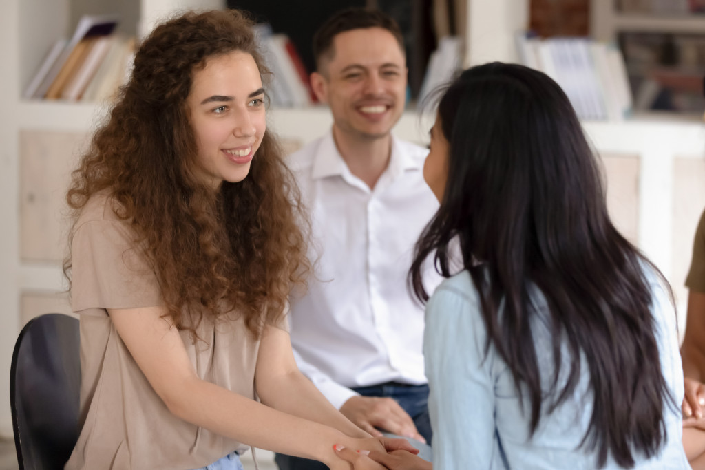 Young woman holding another woman's hand to express gratitude.