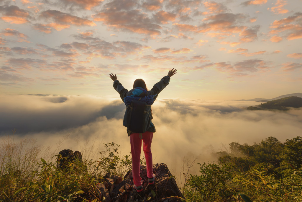 woman celebrating in the top of a hiking trip