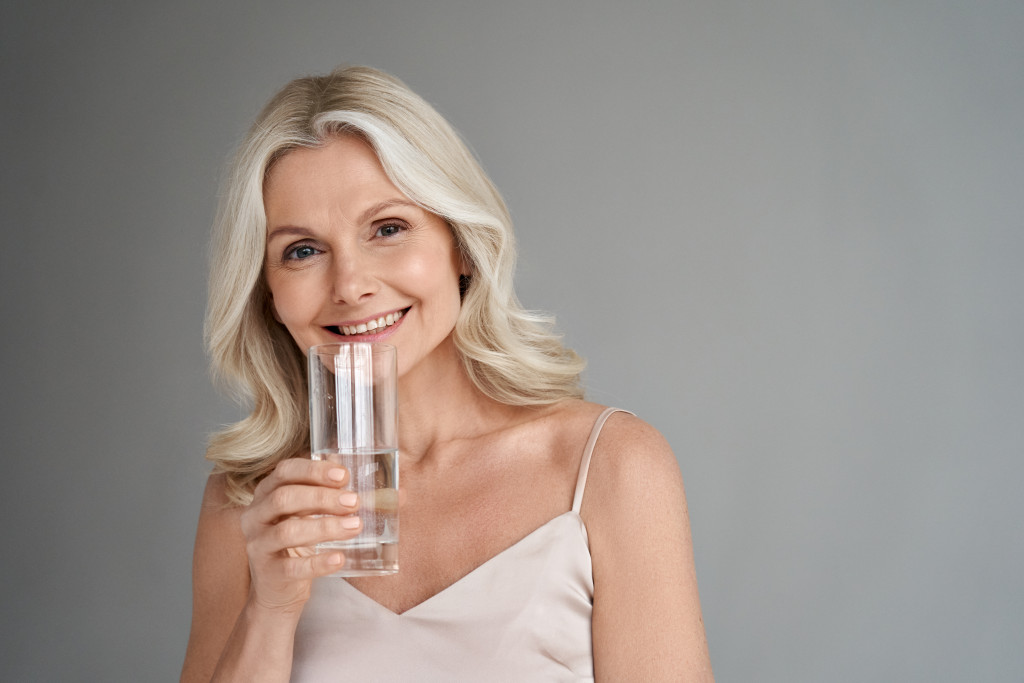 A senior woman holding a glass of water