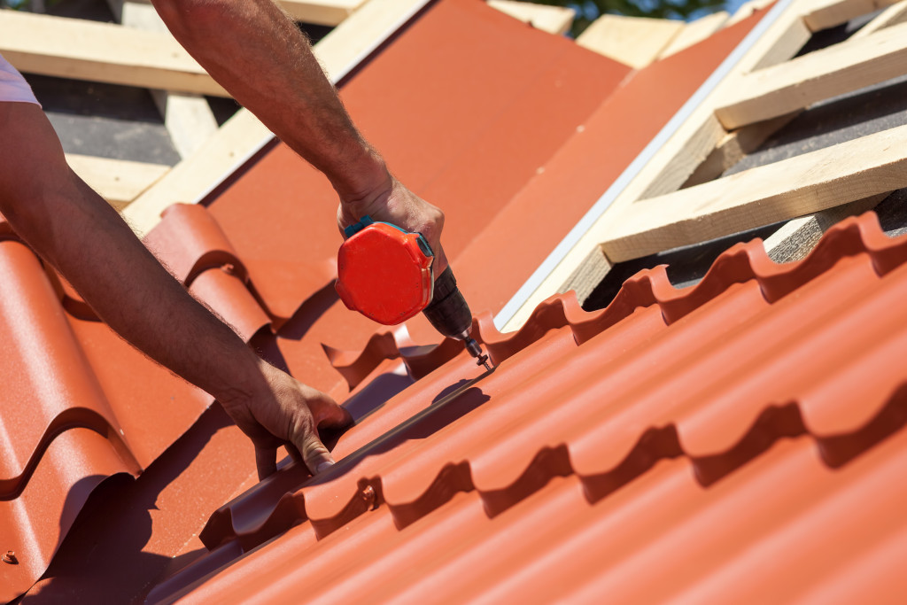 a man repairing the roof using a tool